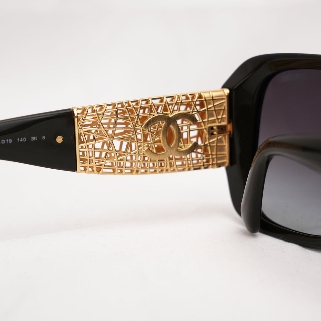 Chanel occhiali da sole neri con aste dorate effetto intrecciato CC