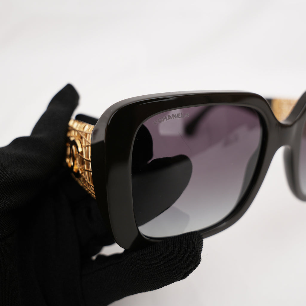 Chanel occhiali da sole neri con aste dorate effetto intrecciato CC