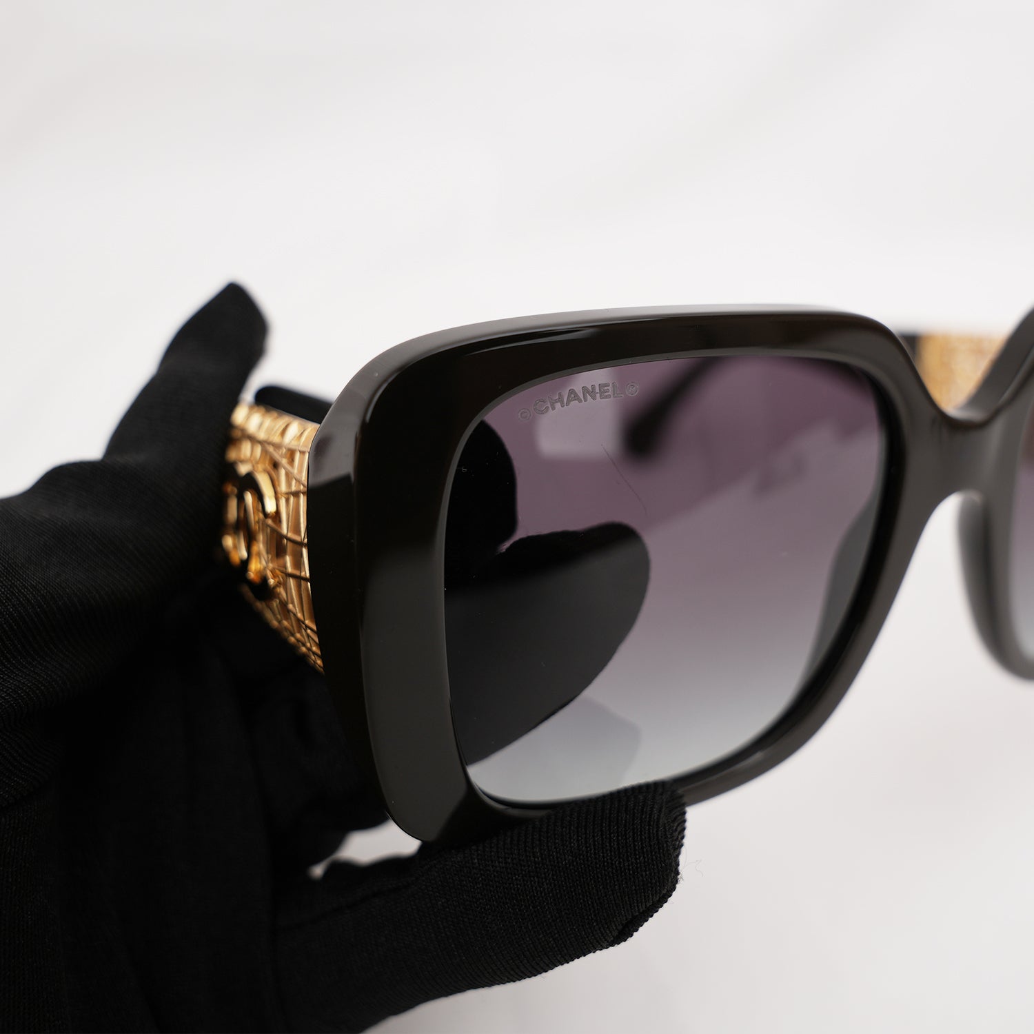 Chanel occhiali da sole neri con aste dorate effetto intrecciato CC