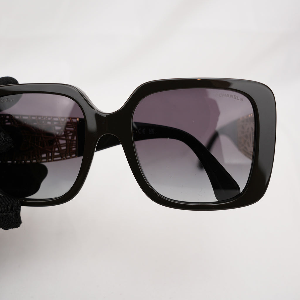 Chanel occhiali da sole neri con aste dorate effetto intrecciato CC