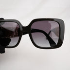 Chanel occhiali da sole neri con aste dorate effetto intrecciato CC