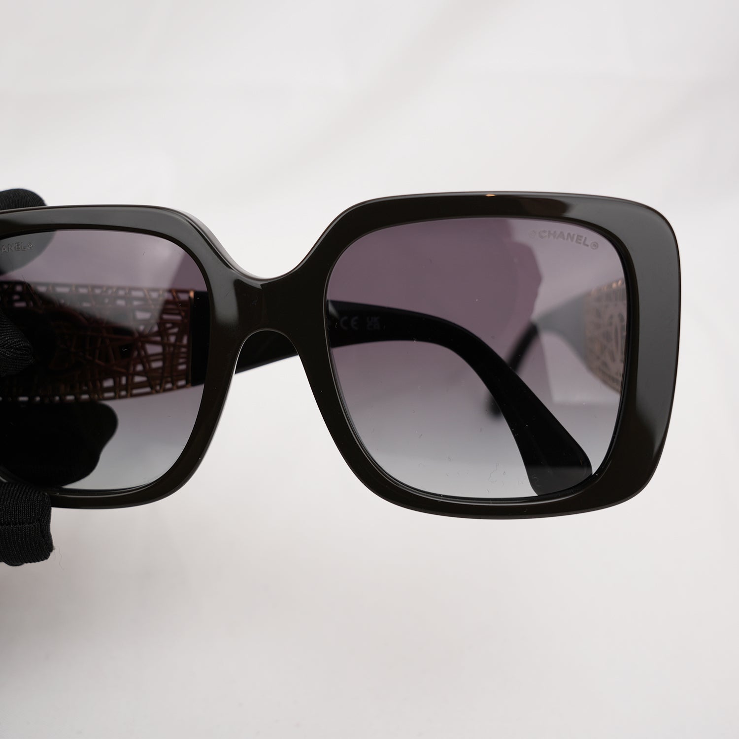 Chanel occhiali da sole neri con aste dorate effetto intrecciato CC