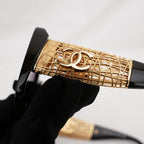 Chanel occhiali da sole neri con aste dorate effetto intrecciato CC