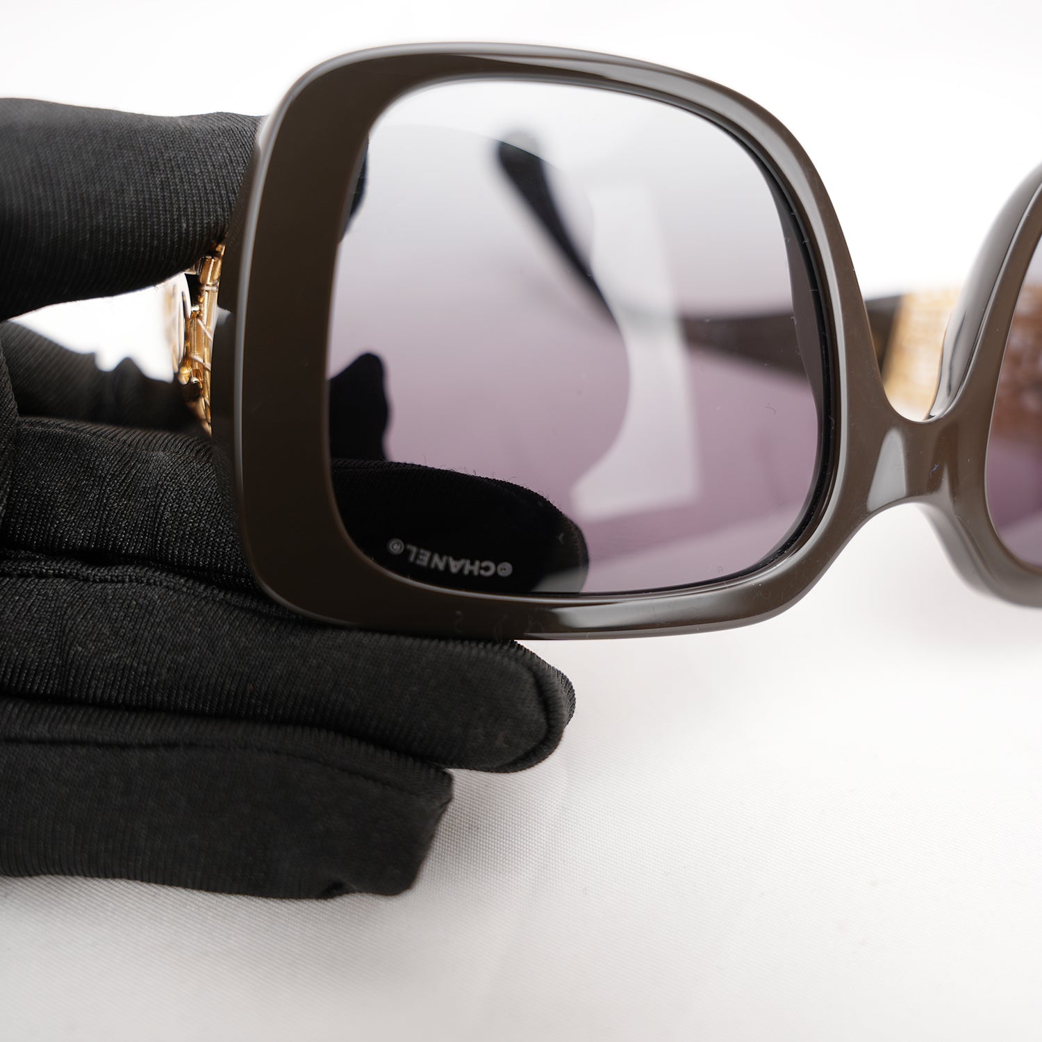 Chanel occhiali da sole neri con aste dorate effetto intrecciato CC