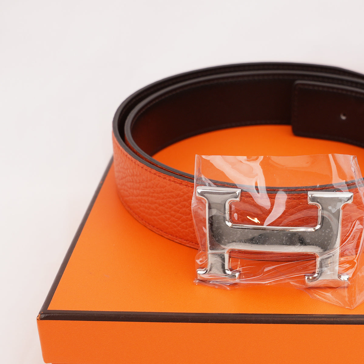 Hermès Cintura Reversibile H Martelée 85 in Pelle Arancione e Marrone Scuro con Fibbia H Argentata e Scatola